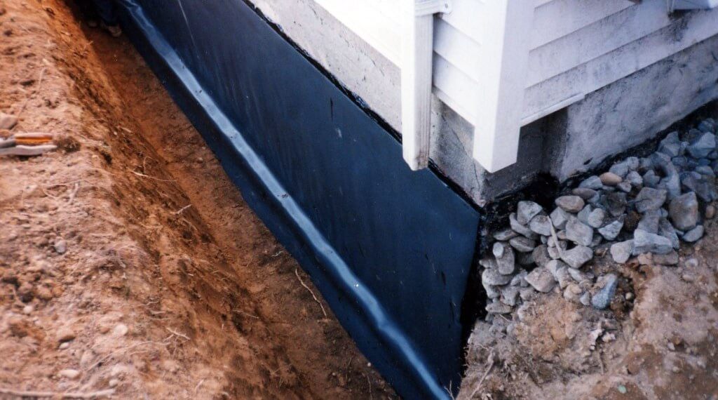 Exposed exterior of basement foundation with surrounding soil pushed away