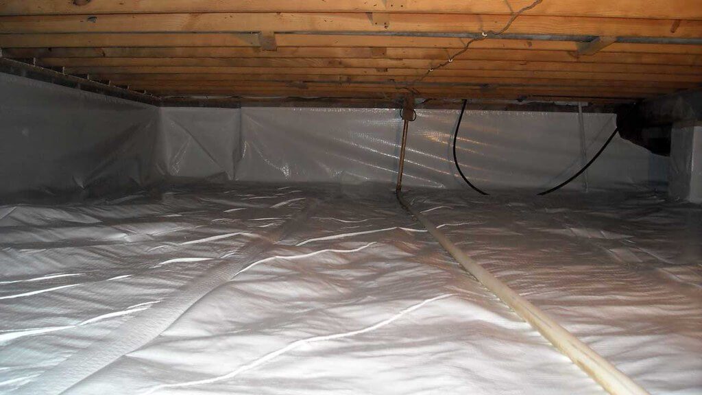 Home crawl space with pipes, insulation, and wood beams showing on upper portion